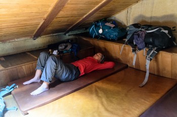Chris resting on one of the mattresses on the attic floor, Granon